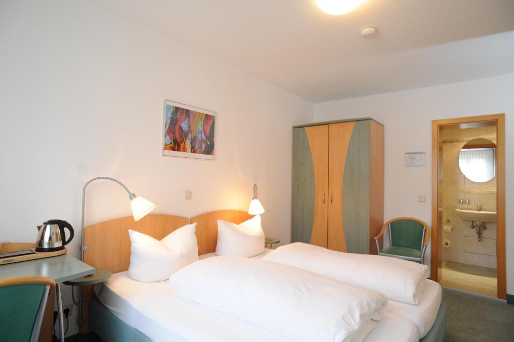斯图加特中心经典酒店的卧室配有2张白色的床、书桌和水槽。