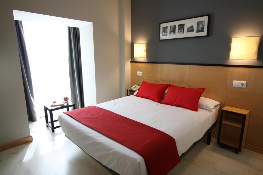 布尔戈斯阿尔达恩特雷亚哥斯酒店的一间卧室配有一张带红色枕头的大床