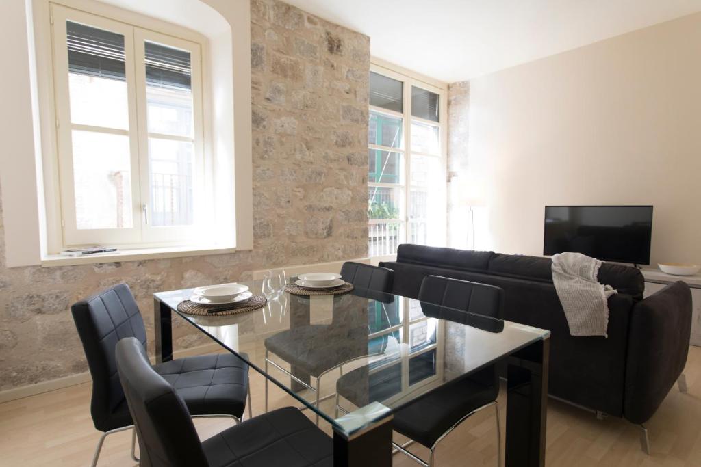赫罗纳Bravissimo Cort Reial-1A的客厅配有玻璃桌和沙发