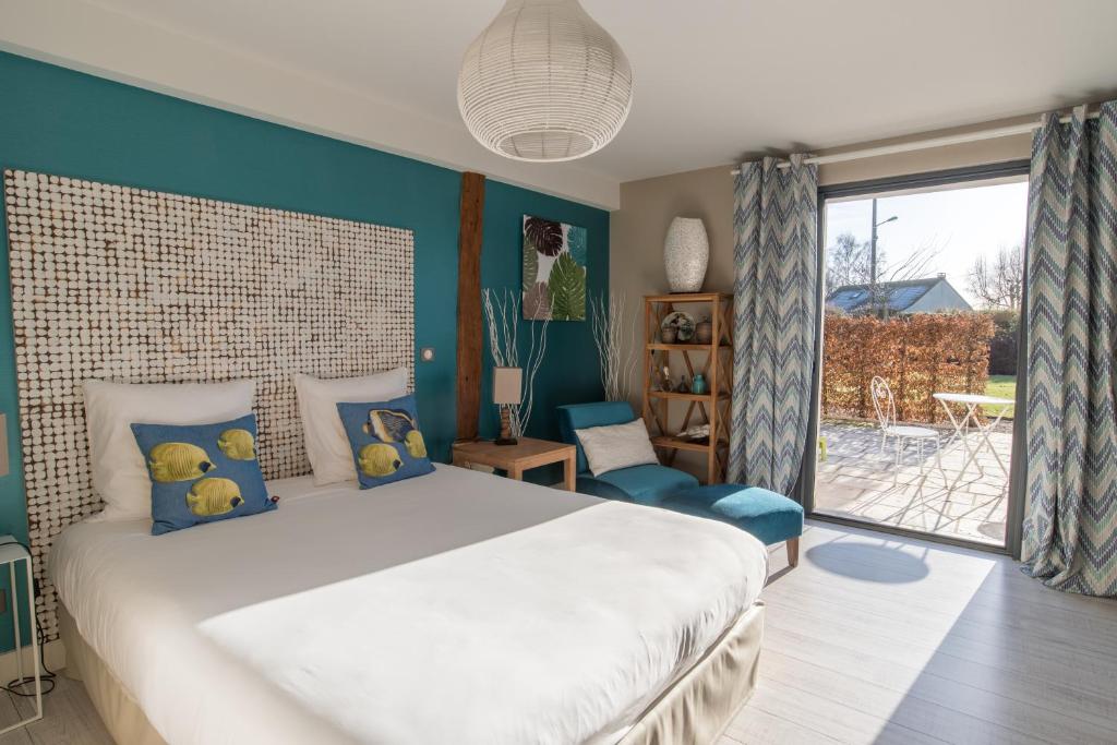 Tillé桑斯奥克斯5号酒店的一间卧室配有一张带蓝色墙壁的大床