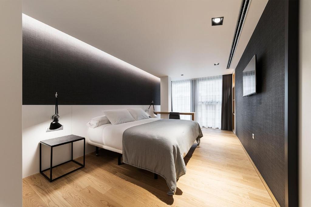 比韦罗Hotel U Viveiro的卧室配有白色的床和黑色墙壁