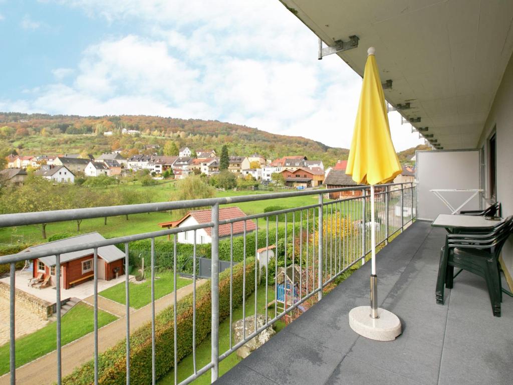 博伦多夫Forest view Apartment in Bollendorf with Large Balcony的阳台配有黄色雨伞和书桌。