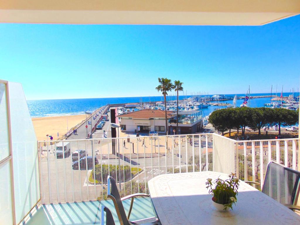 坎布里尔斯沃拉马尔公寓的阳台配有桌子,享有海滩美景