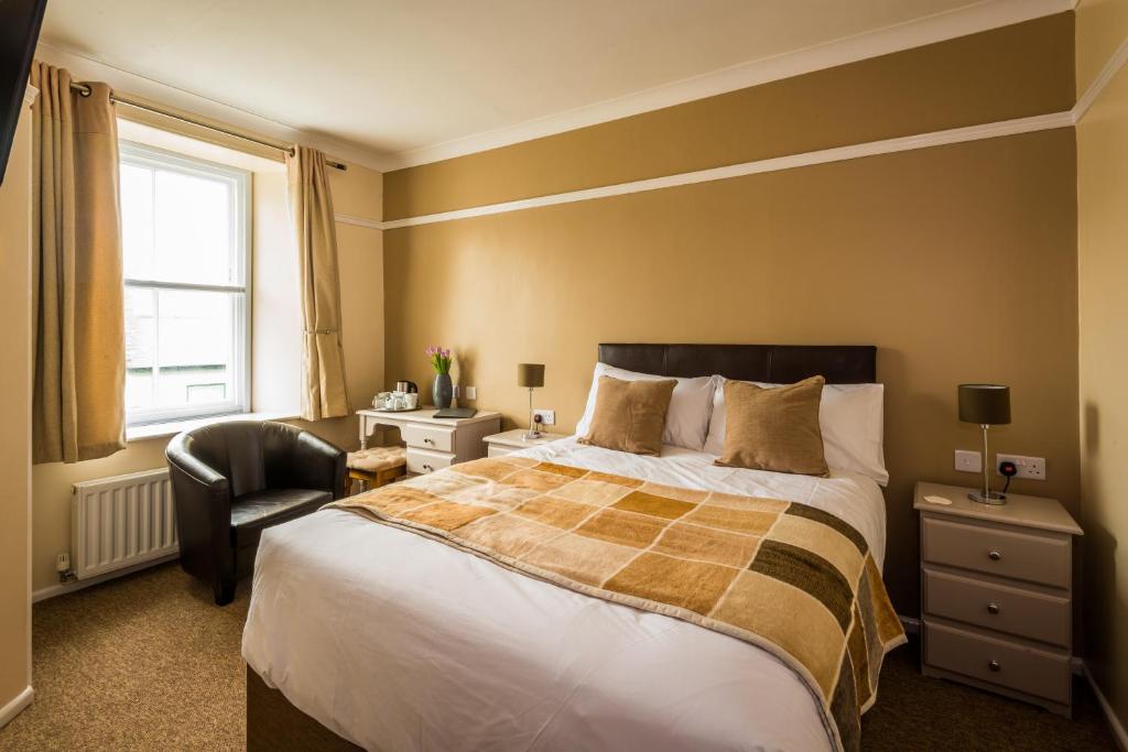 彭赞斯长船旅馆的一间卧室配有一张大床和一把椅子