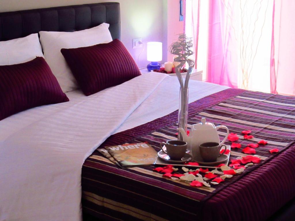 菲乌米奇诺罗马机场就寝飞行酒店的一张带鲜花和杯子托盘的床