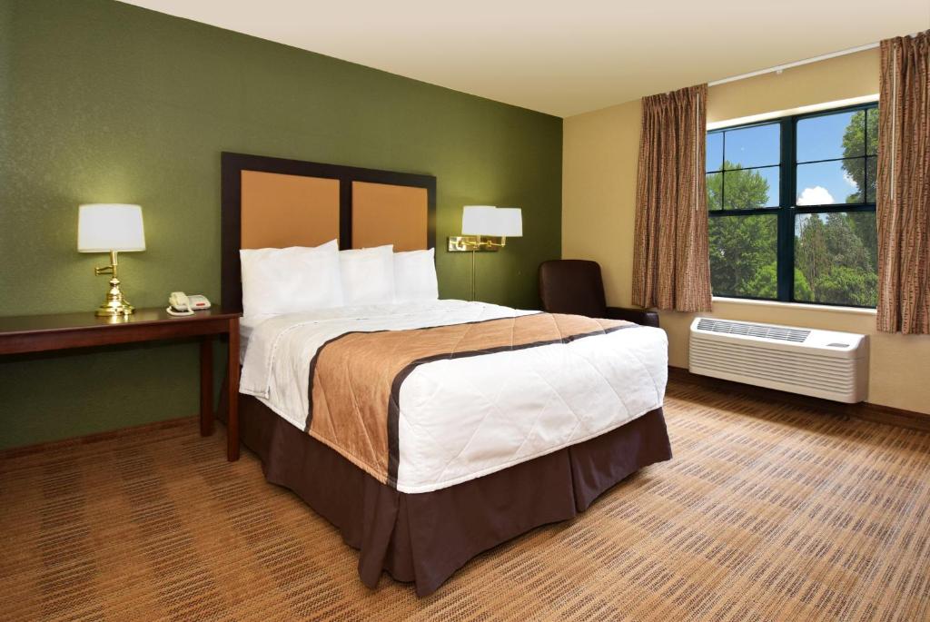 拉斐特Sonesta Simply Suites Lafayette Airport的一间设有大床和窗户的酒店客房