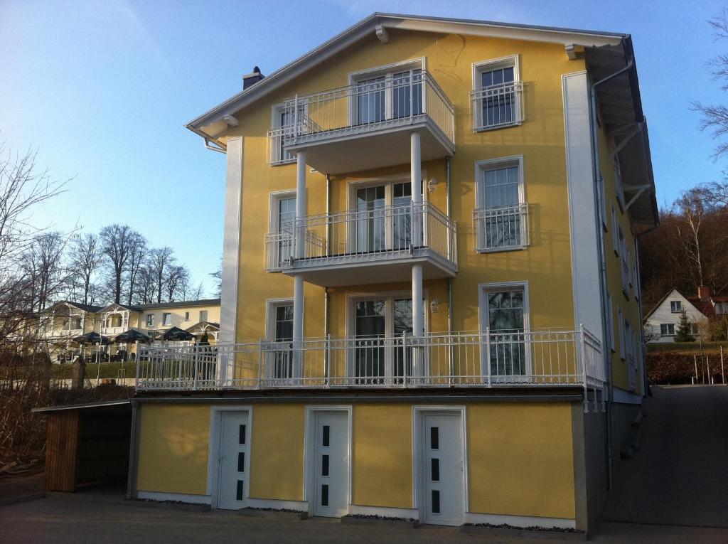 奥斯赛拜-塞林吕根岛别墅酒店的黄色的建筑,设有白色的窗户和阳台