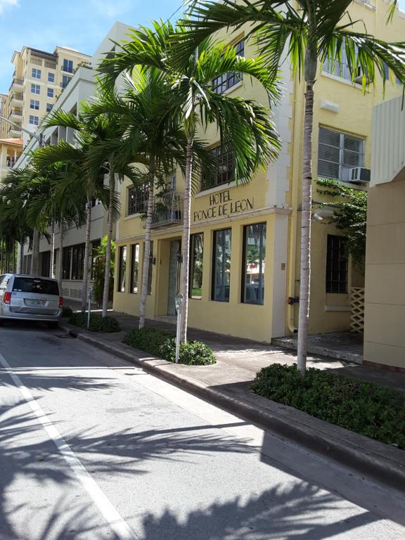 迈阿密普昂斯里昂酒店的街道前方有棕榈树的建筑