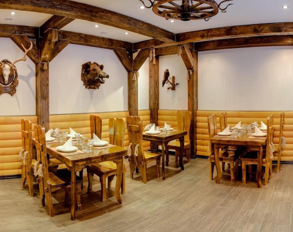 塔塔里夫森林之家酒店的用餐室配有木桌和椅子