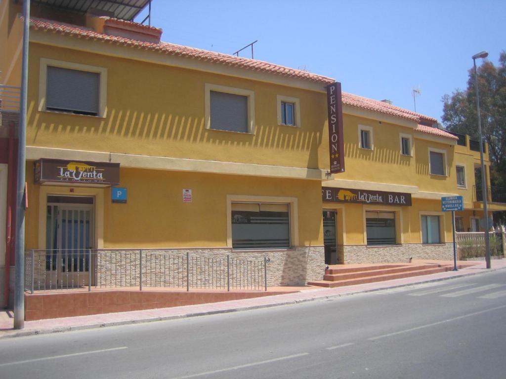 马萨龙港Pensión La Venta的街道边的黄色建筑