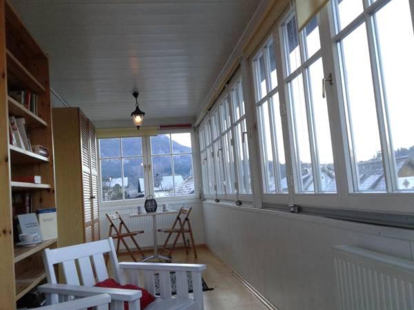 巴德伊舍路易斯度假屋的客房设有窗户、两把椅子和一张桌子