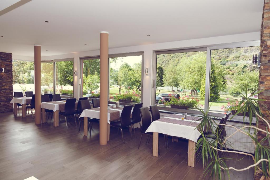 特赖斯-卡尔登加尼海斯酒店的餐厅设有桌椅和大窗户。