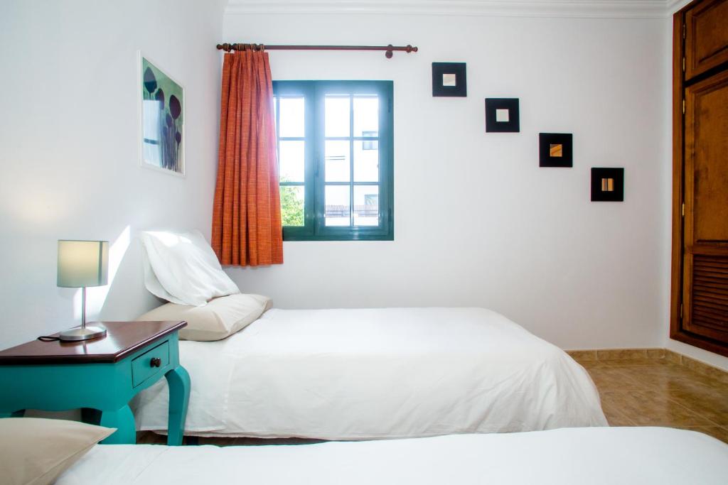 卡门港阳光高尔夫别墅的一间卧室设有两张床和窗户。