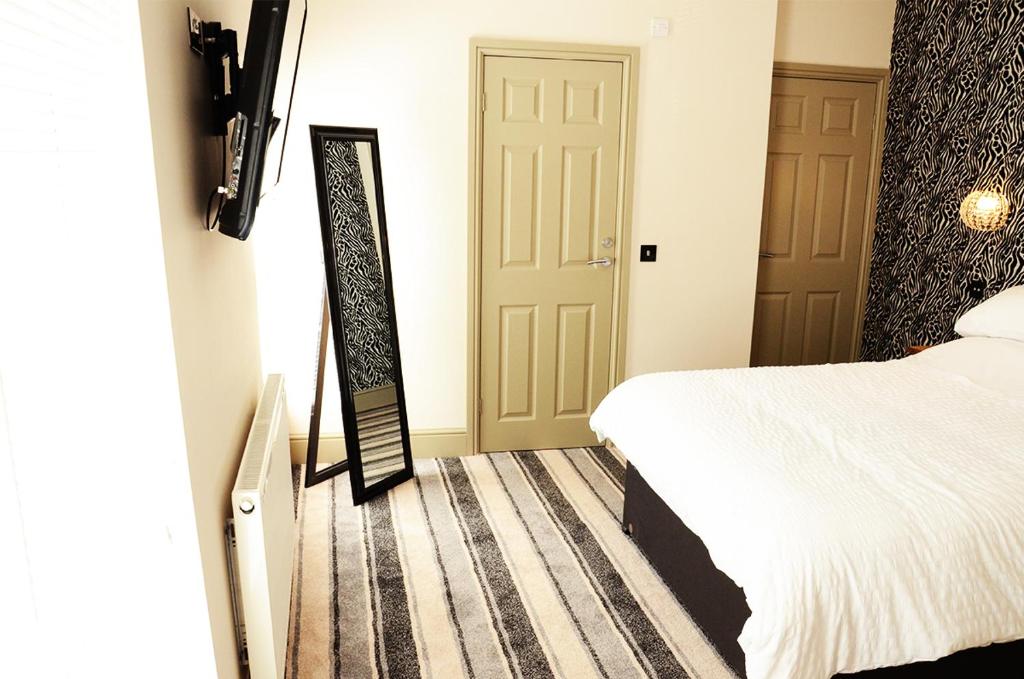 迪斯利Frankies Wine Bar & Lodge的卧室配有一张床,门旁设有镜子
