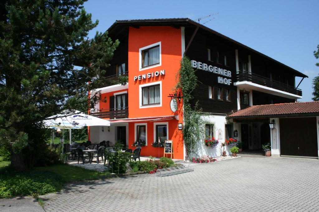 卑尔根贝格内霍夫酒店的一座橙色的建筑,前面设有桌椅