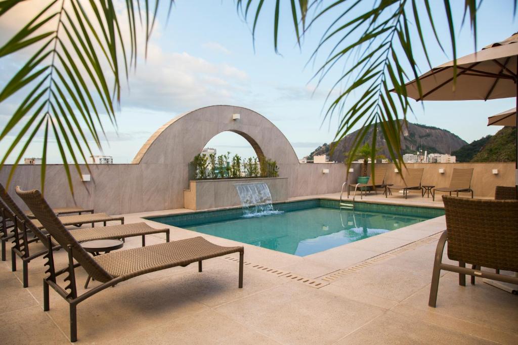 里约热内卢米拉多里约科帕卡巴纳酒店的一个带椅子和遮阳伞的游泳池