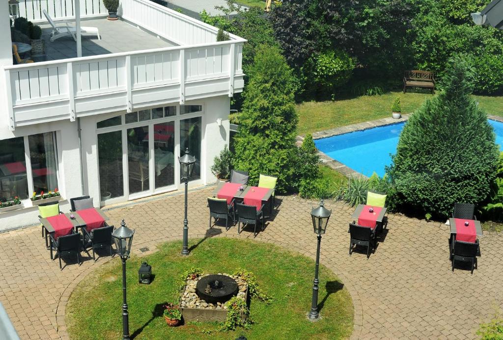 圣英贝特Hotel Restaurant Sengscheider Hof的享有带桌椅和游泳池的庭院的空中景致。