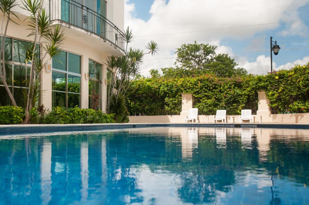 坎昆Boutique House Cancun by Elevate Rooms的一座带椅子的游泳池以及一座建筑
