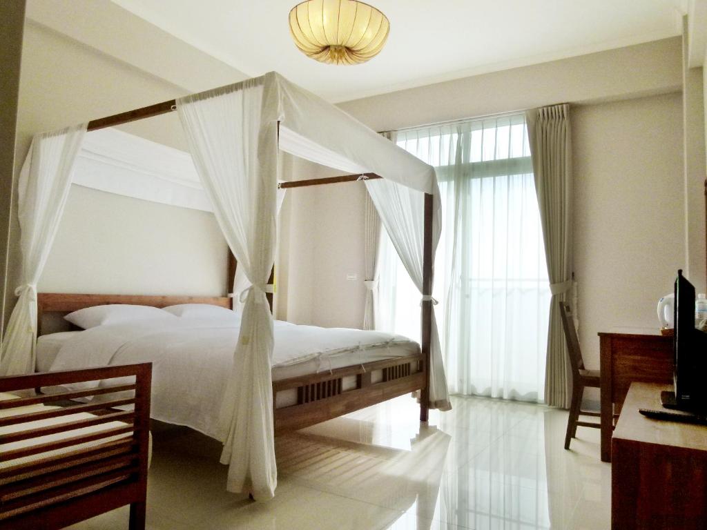 白沙乡吉貝島民宿-德芬旅館Down Home Hotel的一间卧室配有一张带天蓬的床