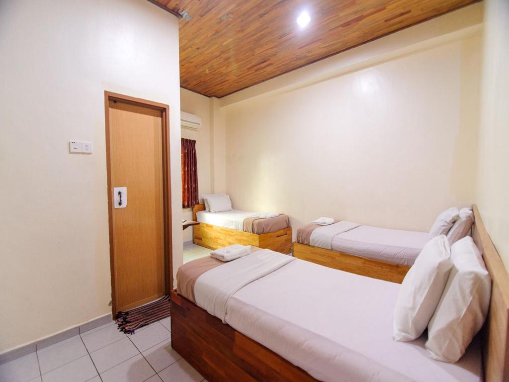 马六甲Y＆Z酒店的一间卧室设有两张床,一扇门通往房间