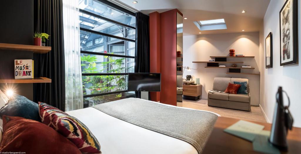 巴黎弗莱德酒店的一间卧室配有一张床、一张沙发和一个窗口