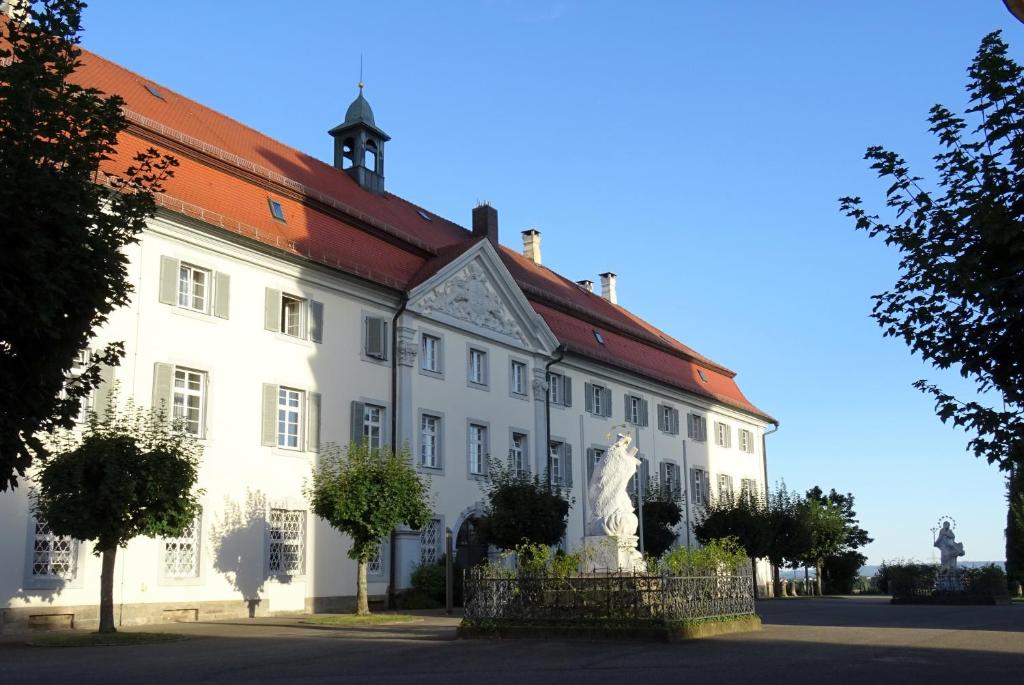 埃尔万根塔格恩豪斯舍嫩贝格酒店的前面有雕像的白色建筑