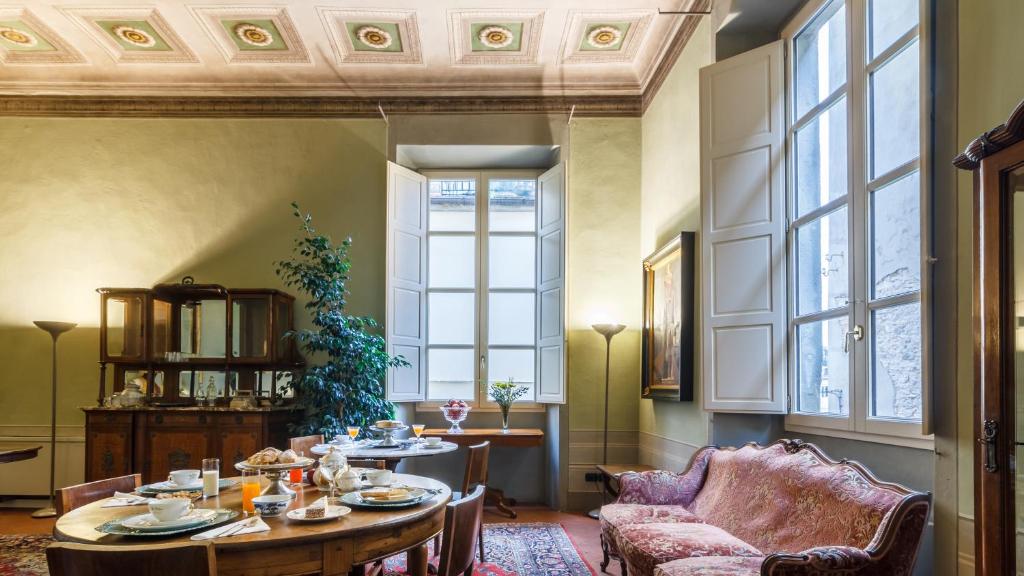 皮斯托亚Dimora Storica Palazzo Puccini的一间带桌子和椅子的用餐室