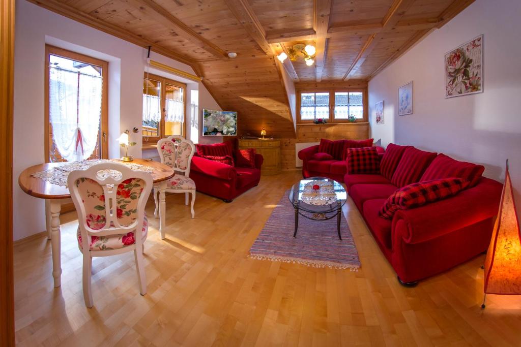 韦尔塔赫Ferienwohnung mit eigener Sauna的客厅配有红色的沙发和桌子