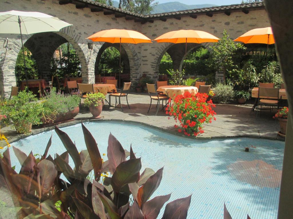 阿斯科纳阿卡迪亚酒店的一个带遮阳伞和桌椅的游泳池
