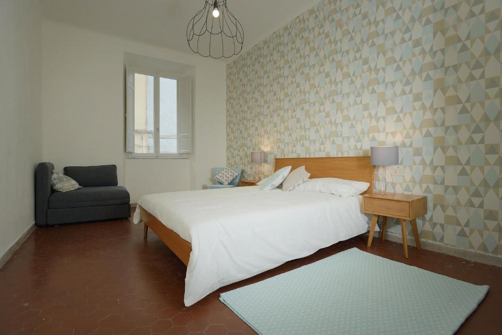 彼得拉桑塔Le camere di Sementis的卧室配有一张白色大床和一把椅子