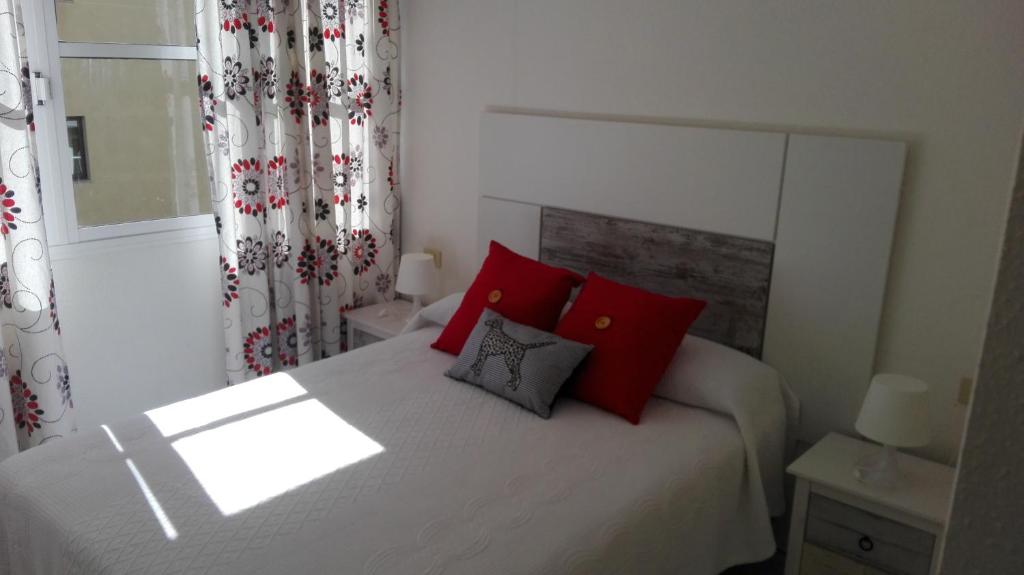 厄尔梅达诺Montaña Roja的一间卧室配有一张带红色枕头的床和一扇窗户