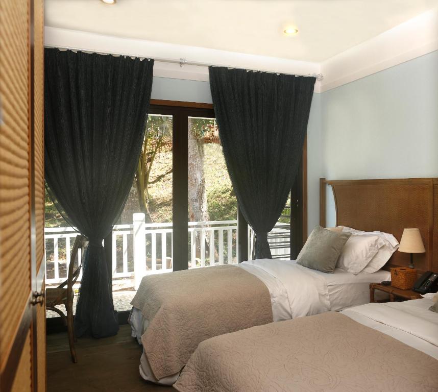 科罗尔贝壳度假公寓式酒店的酒店客房设有两张床和一个阳台。