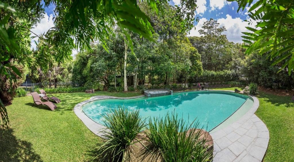 马莱尼Spicers Tamarind Retreat的一座树木繁茂的庭院内的游泳池
