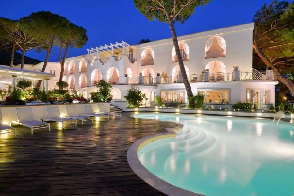 阿西亚罗利La Pineta Hotel Beach & Spa的夜间设有游泳池的酒店