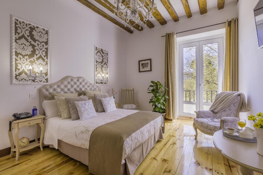 马德里奥连特宫公寓的一间卧室配有一张床、一张桌子和一个窗户。