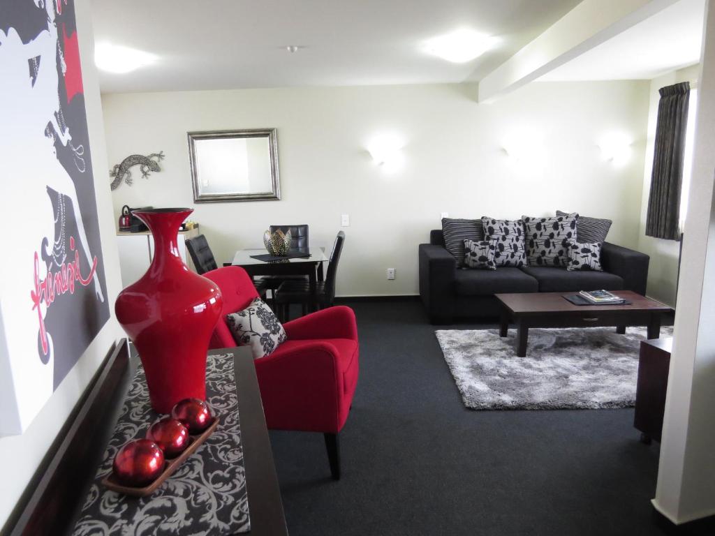 因弗卡吉尔家园别墅汽车旅馆的客厅配有红色椅子和沙发