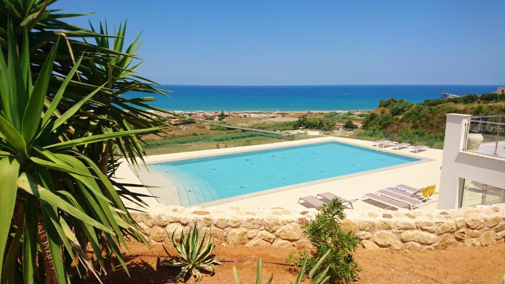 卡斯泰拉马莱La Blanca Resort & Spa的一个带椅子的游泳池,背景是大海