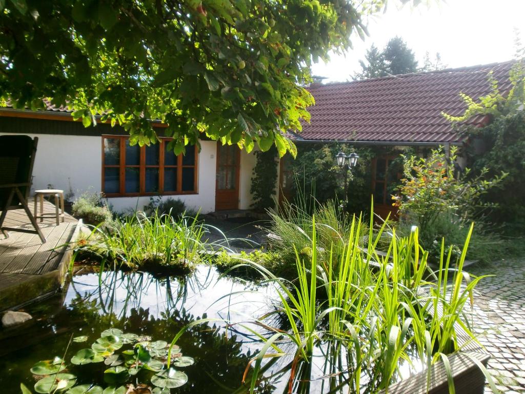 策勒Kastanienhof Alvern的房屋前带池塘的花园