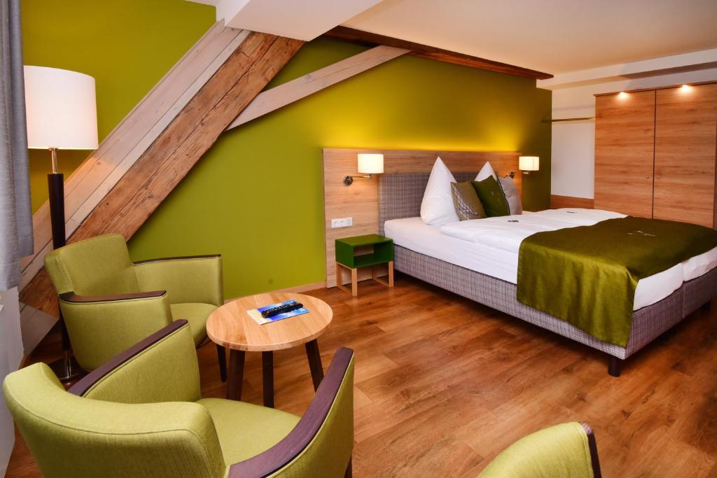 Wolframs-Eschenbach阿尔特沃格泰酒店的卧室配有一张床和一张桌子及椅子