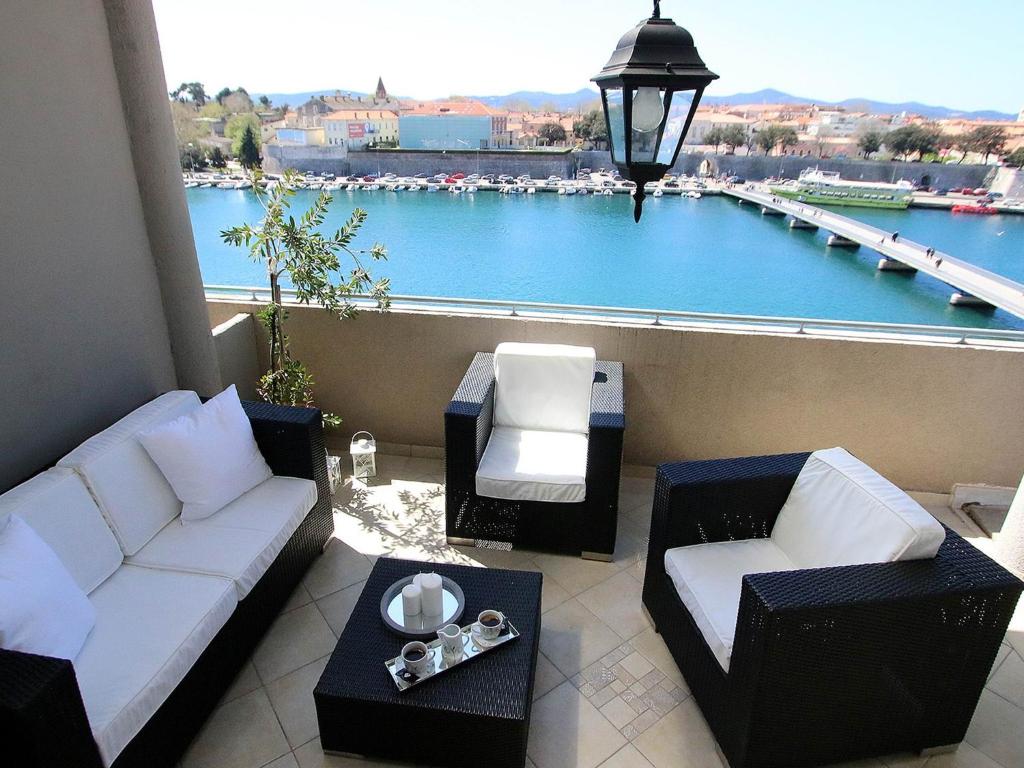 扎达尔The View的阳台配有沙发,享有海港景色