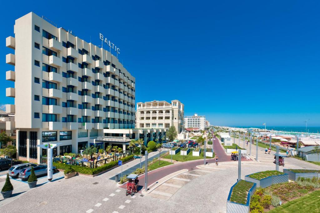 里乔内Hotel Baltic Riccione-Fronte Mare的享有街道、大楼和海滩的景致。
