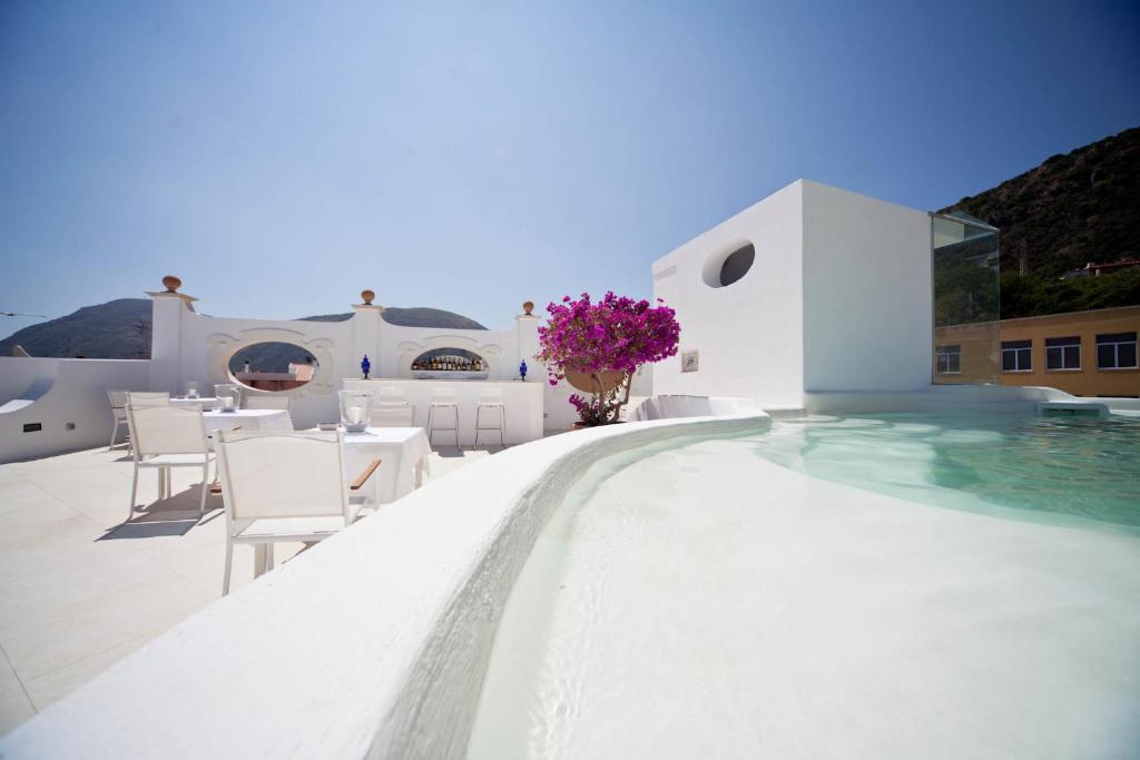 坎内托拉塞迪玛露娜酒店的一座带白色桌椅和鲜花的游泳池