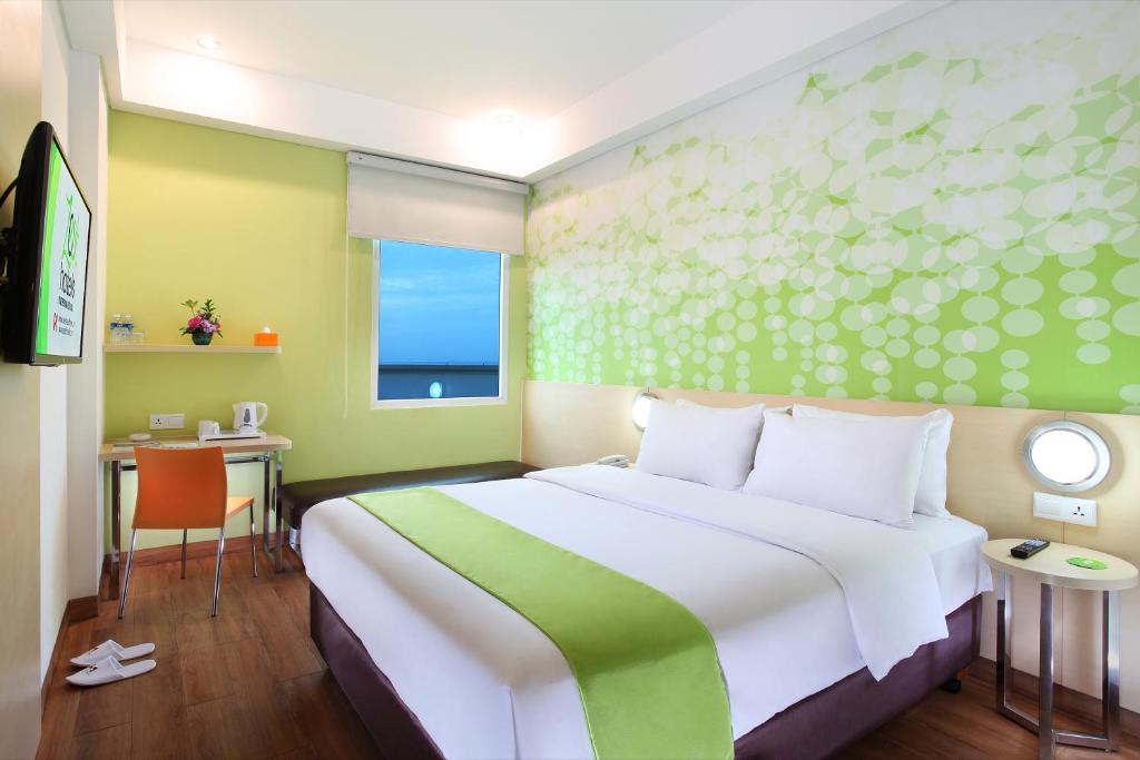 当格浪Zest Airport Jakarta by Swiss-Belhotel International的卧室设有一张白色大床和一扇窗户。