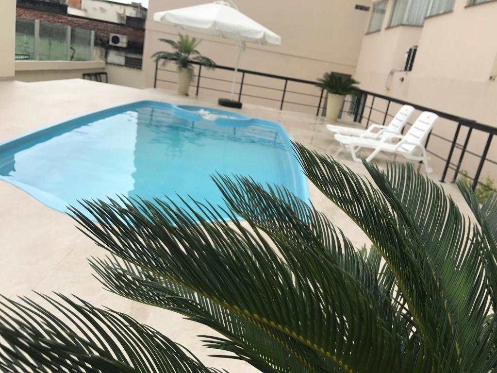 雷森迪雷森迪酒店 的棕榈树阳台的蓝色游泳池