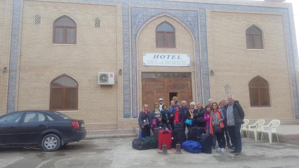 希瓦Islambek Hotel & Travel的一群站在建筑物前的人