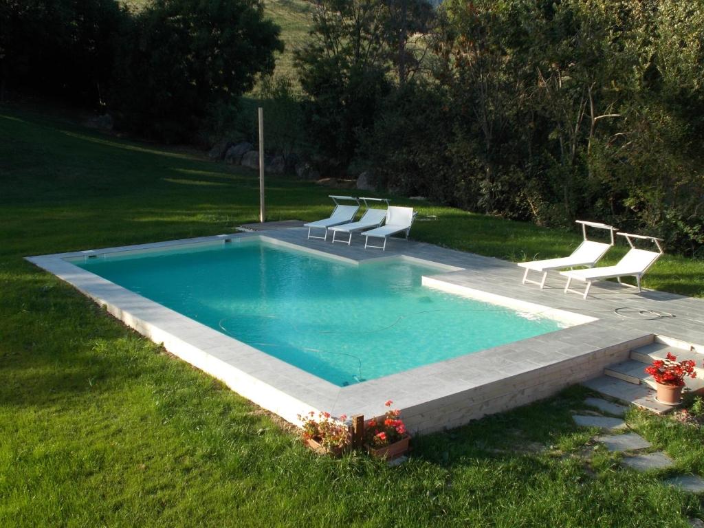 卡尔佩尼亚Country House "Locanda Le Querce"的庭院内带躺椅的游泳池