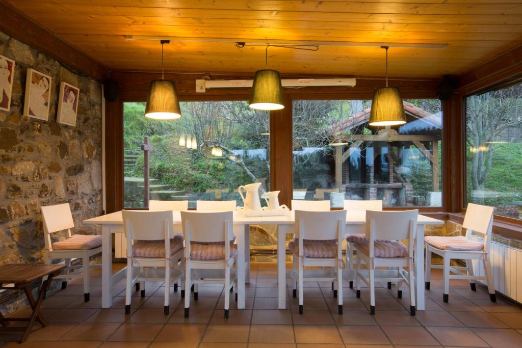 EaCasa Rural Andutza的一间配备有白色桌椅的用餐室