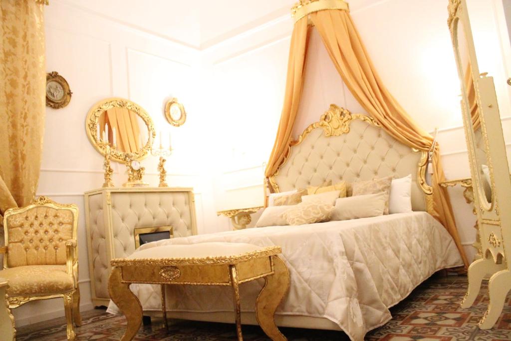 比谢列DONNA LUCREZIA b&b Boutique Hotel Style的一间卧室配有一张带桌子和椅子的天蓬床