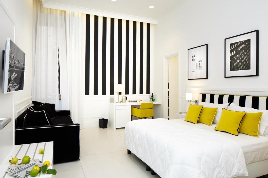 那不勒斯娜普豪华旅馆的白色卧室配有一张带黄色枕头的大床
