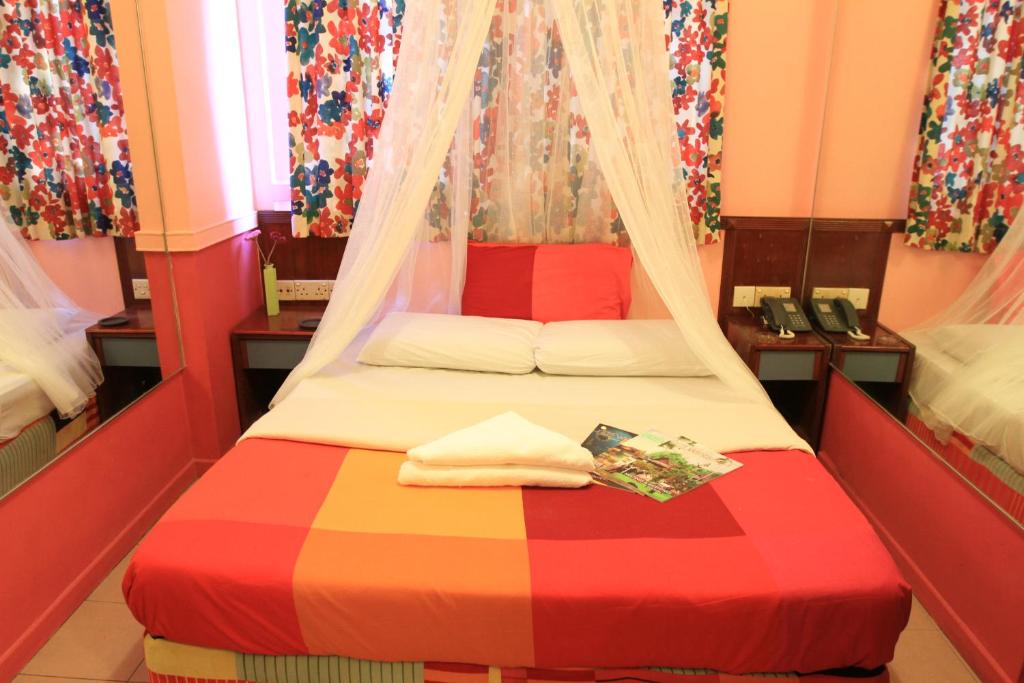 新加坡拉摩德（索菲亚）酒店的一间卧室配有一张带彩色毯子的床